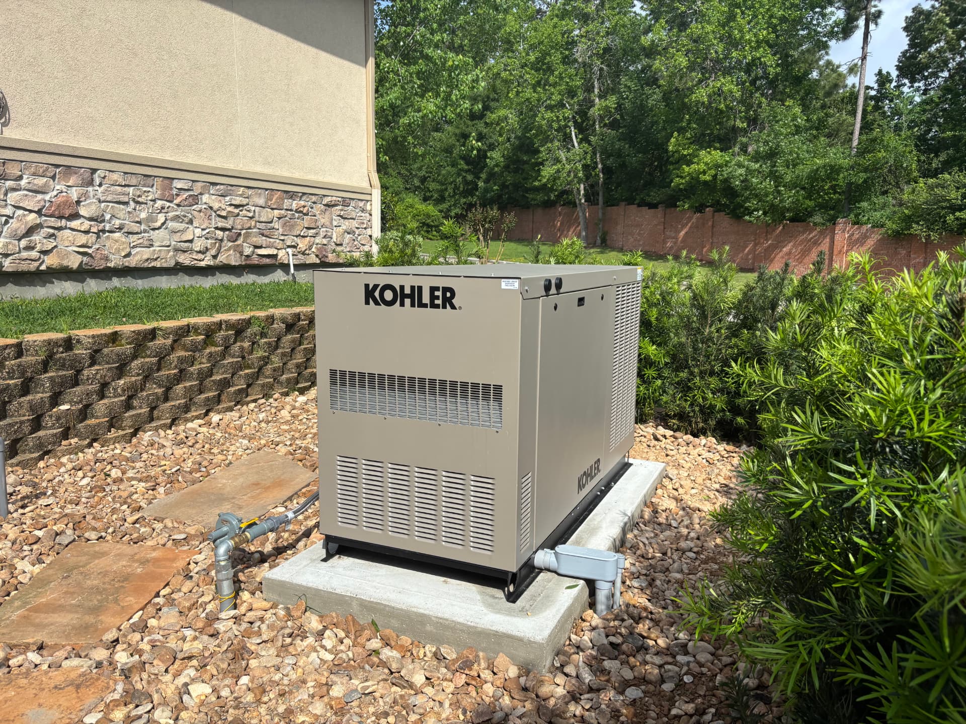 Liquid-cooled Kohler standby generator installed in a landscaped backyard