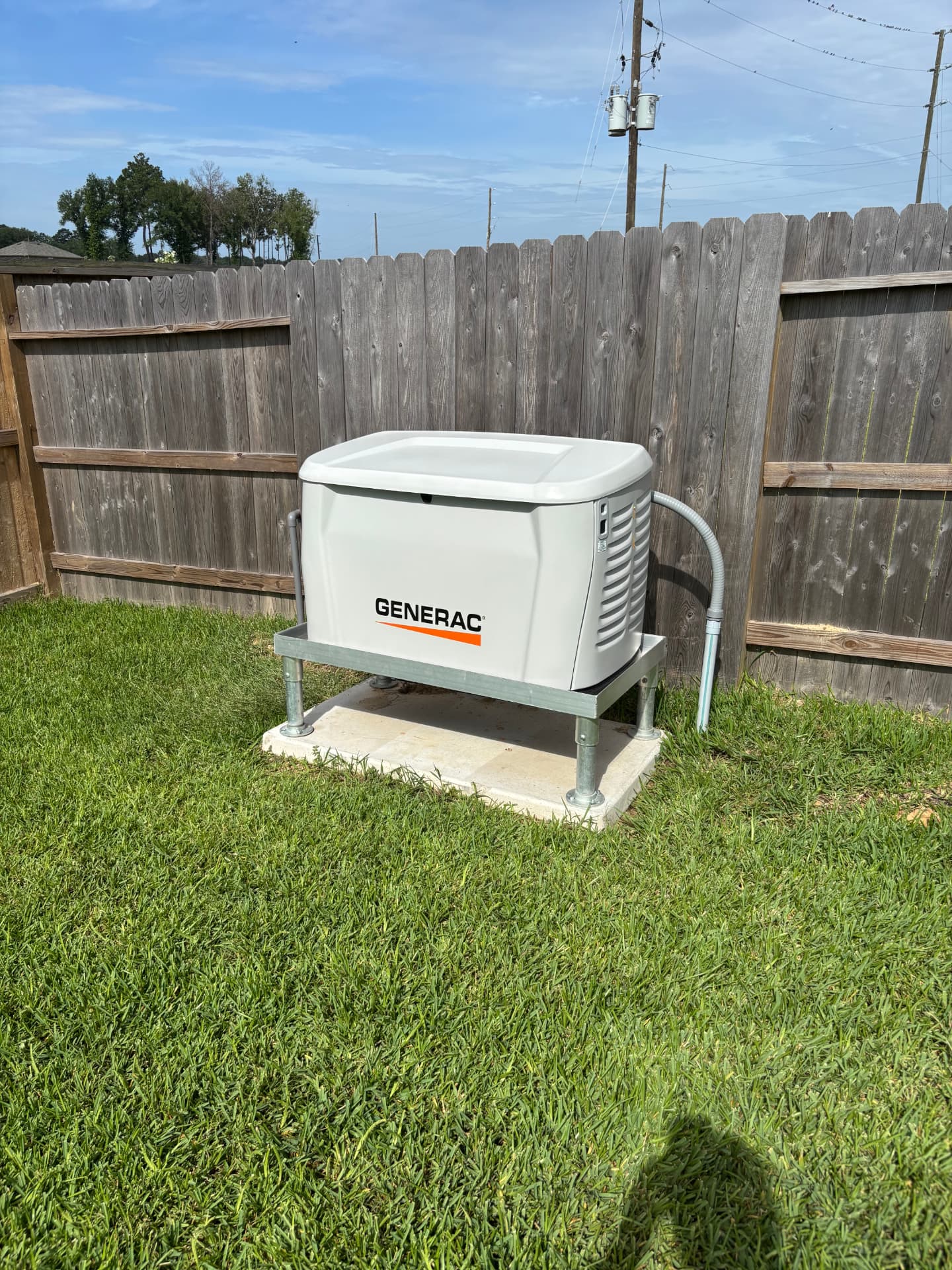 Generac standby generator elevated on a galvanized flood-rated stand